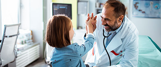 Doctor giving young female patient a high 5